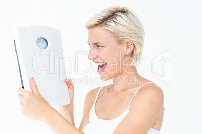 Happy blonde woman holding scales