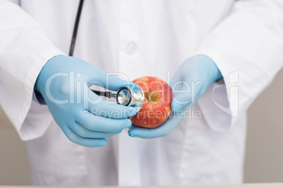 Scientist listening apple with stethoscope