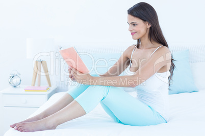 Beautiful woman reading on her bed