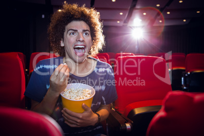 Happy young man watching a film