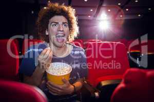 Happy young man watching a film