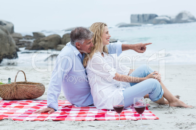 Happy couple sitting on a blanket and hugging each other Happy couple sitting on a blanket and hugging each other