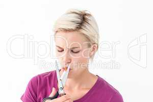 Beautiful blonde cutting a cigarette