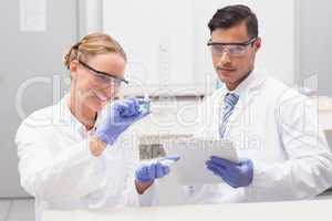 Scientists looking at petri dish and taking notes