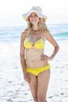 Smiling pretty blonde in bikini wearing straw hat