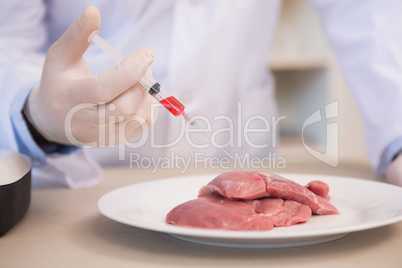 Scientist doing injection to pieces of meat