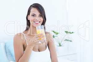 Pretty woman looking at camera holding glass of juice