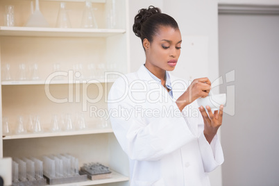 Concentrated scientist using pestle and mortar