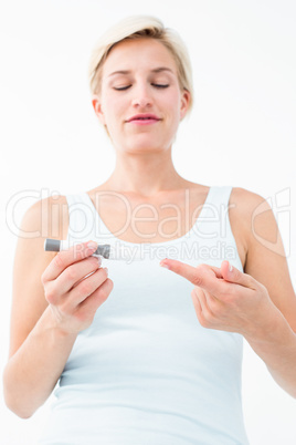 Smiling woman testing her blood glucose level