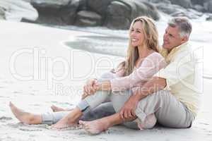 Happy couple sitting on the sand