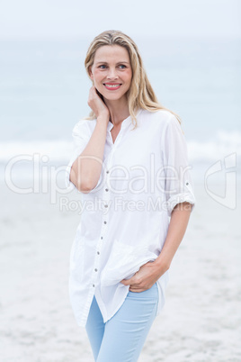 Smiling blonde standing by the sea