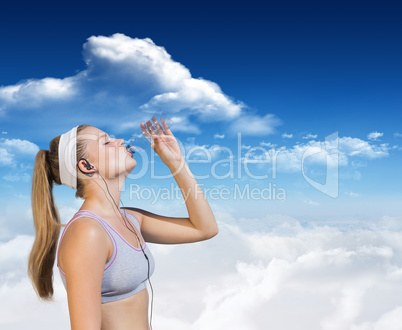 Composite image of sporty blonde drinking water