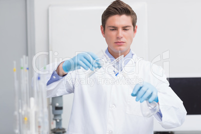 Scientist pouring chemical product in funnel