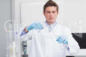 Scientist pouring chemical product in funnel