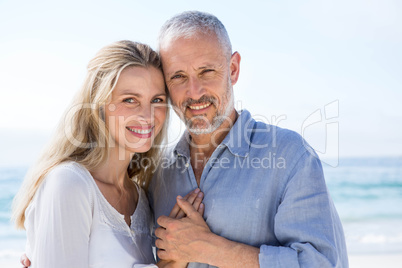 Happy couple hugging each other and looking at camera