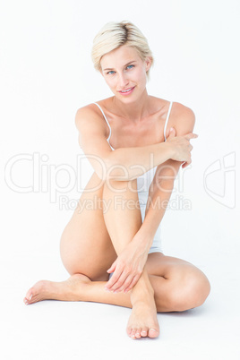 Gorgeous blonde sitting on the floor smiling at camera