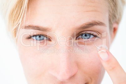 Pretty blonde applying contact lens