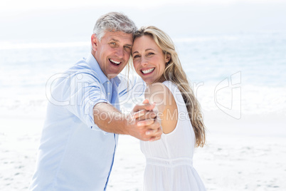 Happy couple holding hands and smiling at camera