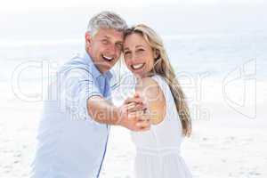 Happy couple holding hands and smiling at camera