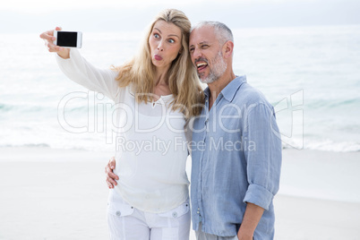 Happy couple taking selfie with mobile phone