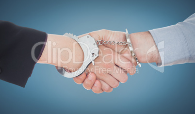 Composite image of business people in handcuffs shaking hands