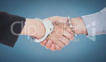 Composite image of business people in handcuffs shaking hands