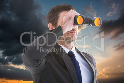 Composite image of young businessman looking through binoculars