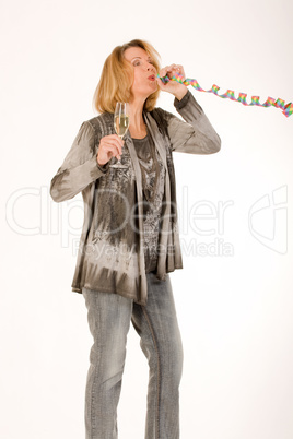 ältere Frau pustet beim feiern eine Luftschlange aus