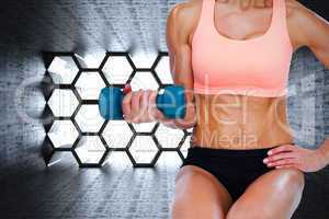 Composite image of strong woman doing bicep curl with blue dumbb