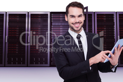 Composite image of businessman using his tablet while looking at Composite image of businessman using his tablet while looking at