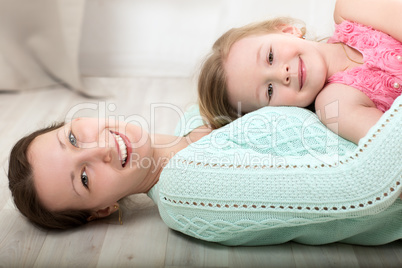 Smiling mother and daughter on the floor