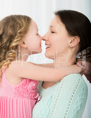 Mother and daughter touching with noses