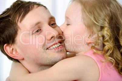 Little girl kissing fathers cheek