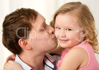 Daddy kissing beautiful little daughter