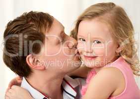 Daddy kissing beautiful little daughter