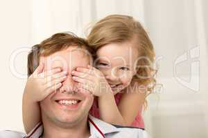 Daughter playing with father closing his eyes