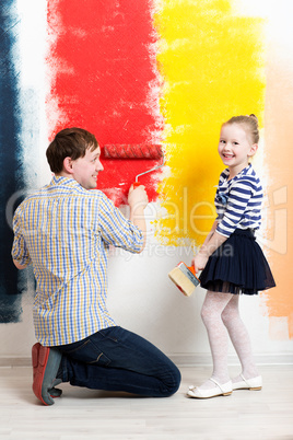 Happy girl painting wall with father