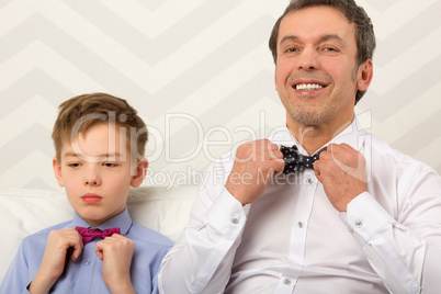 Father and son adjusting bowties