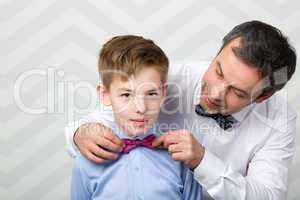 Father adjusting sons bowtie