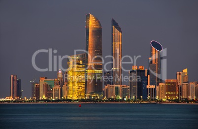 Skyline von Abu Dhabi im Abendlicht mit Wasser im Vordergrund
