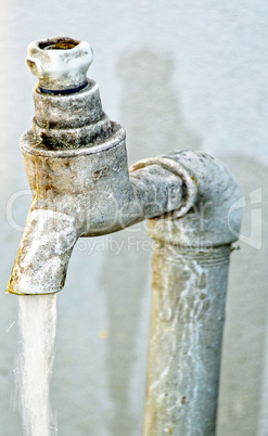 Tap of running water isolated on grey background