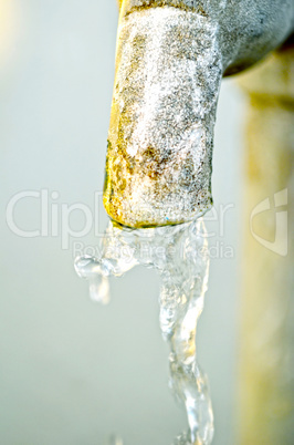 Tap of running water isolated on grey background