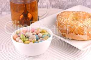 A cup of tea with a cake and candies