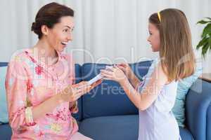 Little girl giving her mother a gift