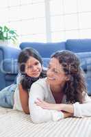 Happy mother and daughter lying on the floor