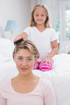 Daughter brushing her mothers hair