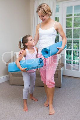Mother and daughter with yoga mats