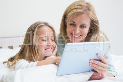 Happy mother and daughter using tablet