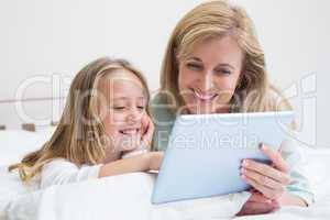 Happy mother and daughter using tablet