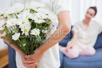 Daughter giving mother white bouquet